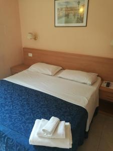 um quarto de hotel com uma cama com toalhas em Palma em Roma