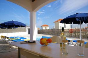 a table with a bowl of fruit and a bottle of wine at Vv Tirma in Caleta De Fuste