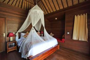 1 dormitorio con 2 camas con mosquiteras en Dream Beach Cottages, en Nusa Lembongan