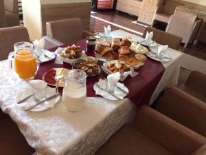 een tafel met borden eten en drinken erop bij Hotel Millenium2 in Prizren