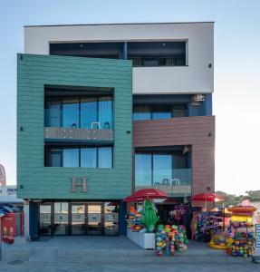 a building with a market in front of it at Hotel H pe plaja Belona in Eforie Nord