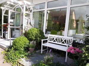 un banc blanc devant un magasin de fleurs dans l'établissement Hotel Garni Sand, à Tübingen