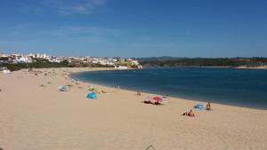 un groupe de personnes se posant sur une plage dans l'établissement Apartamento Estúdio Pinhalmar, à Vila Nova de Milfontes