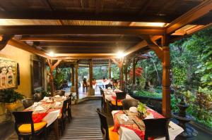 een eetkamer met tafels, stoelen en bomen bij Sri Phala Resort & Villa in Sanur