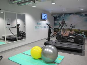 een fitnessruimte met fitnessapparatuur en sportballen op de vloer bij BEST WESTERN Hotel Brussels South in Ruisbroek