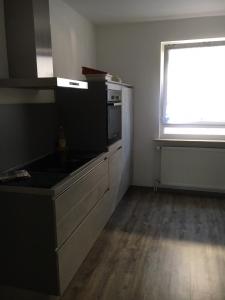 une cuisine vide avec une cuisinière et une fenêtre dans l'établissement Ferienwohnung Pfeifer, à Friedrichsdorf