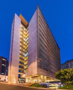 ein hohes Gebäude mit Licht in einer Stadt in der Unterkunft ibis Bogota Museo in Bogotá