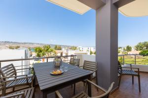 Ethereal Apartments Chania في سودا: طاولة طعام على شرفة المنزل