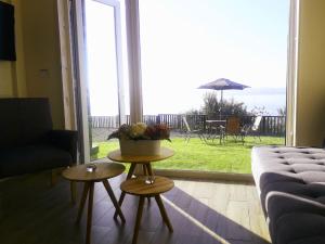 una sala de estar con sofá y mesa con una planta. en ApartHotel Kintumay, en Puerto Varas