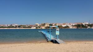 un quai sur une plage avec une ville en arrière-plan dans l'établissement Apartamento Estúdio Pinhalmar, à Vila Nova de Milfontes