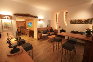 a living room with a couch and a table and chairs at Hotel Trieste in Cortina dʼAmpezzo