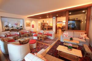 a large living room with couches and tables at Hotel Trieste in Cortina dʼAmpezzo