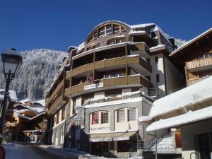 ein Gebäude im Schnee mit einem Berg in der Unterkunft Hotel Viktoria Eden in Adelboden