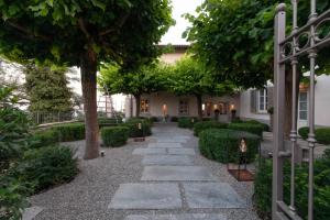 einen Garten mit einem steinernen Gehweg vor einem Haus in der Unterkunft Relais San Vigilio al Castello in Bergamo