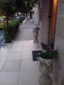 un trottoir avec deux grands vases avec des fleurs dans l'établissement Alexandrov Residence Studio, à Nessebar