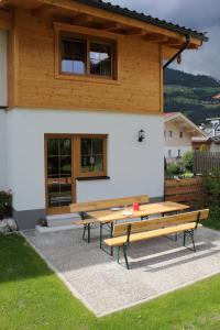 una mesa de picnic frente a una casa en May-Haus, en Bramberg am Wildkogel