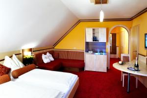 een hotelkamer met een bed, een bank en een koelkast bij Hotel Garni Thermenglück in Unterlamm