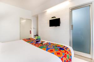 um quarto com uma cama com um cobertor colorido em FabExpress Kalyan - Nr Dairy Dan Circle em Vadodara