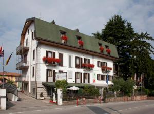 un edificio blanco con flores rojas en las ventanas en Hotel Ungheria Varese 1946, en Varese