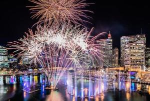 ein Feuerwerk über dem Wasser mit einer Stadt in der Unterkunft Darling Harbour 2 Bedroom Apartment in Sydney