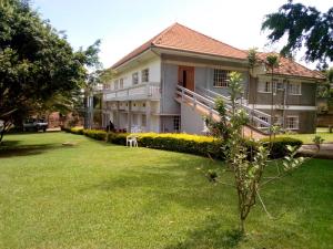 een groot huis met een gazon ervoor bij Skyway Hotel in Entebbe