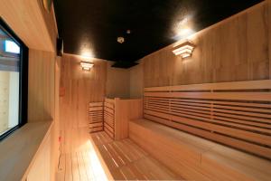 uma sauna com painéis de madeira e luzes em Candeo Hotels Kobe Tor Road em Kobe