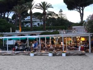 eine Gruppe von Menschen, die in einem Restaurant am Strand sitzen in der Unterkunft Villa Argentina in San Felice Circeo