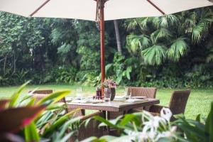 een buitentafel met een parasol en stoelen bij Taj West End in Bangalore