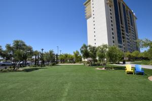 zwei blaue und gelbe Stühle auf einem Rasen vor einem Gebäude in der Unterkunft The Berkley, Las Vegas in Las Vegas