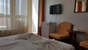 a bedroom with a bed and a chair and a television at Hotel Scoica in Jupiter