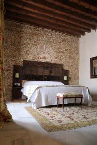 een slaapkamer met een groot bed en een bakstenen muur bij Hotel Casa de las Cuatro Torres in Cádiz