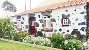 a white house with red windows and a fence at Fisherman's House Azores in Angra do Heroísmo