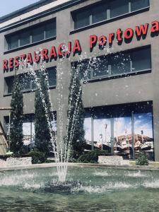 een fontein voor een restaurant met een gebouw bij Hotel Malinowski Business in Gliwice