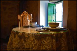 uma mesa com dois copos de vinho em cima em Castelo Cottages II em Monsanto