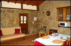 een woonkamer met een tafel en een bank bij Castelo Cottages in Castelo Novo