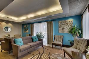 uma sala de estar com um sofá e cadeiras em Wingfield Inn & Suites em Owensboro