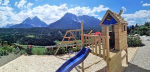 een houten speeltuin met een glijbaan en een glijbaan bij Oberpapping in San Candido