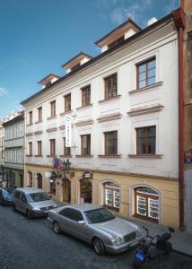 two cars parked in front of a large building at Hostel Little Quarter in Prague