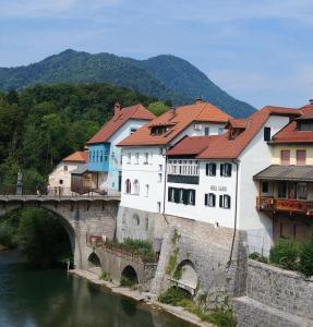 un grupo de edificios en un puente sobre un río en Hotel garni Paleta, en Škofja Loka