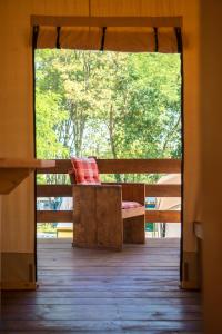 eine Bank mit einem roten Kissen auf einer Veranda in der Unterkunft Sunflower Camping in Novigrad Istria