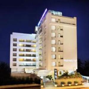 un edificio blanco alto con un letrero de neón. en Yogi Executive, Navi Mumbai, en Navi Mumbai