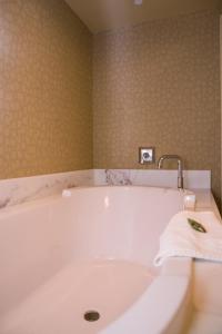 eine weiße Badewanne mit einem Wasserhahn im Bad in der Unterkunft Isle Casino Hotel Bettendorf in Bettendorf