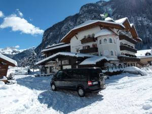 a van parked in front of a building in the snow at Hotel Gran Paradis in Campitello di Fassa