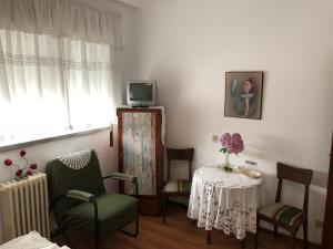 ein Wohnzimmer mit einem Tisch und Stühlen sowie einem TV in der Unterkunft Residencia Maria Jose in Fátima