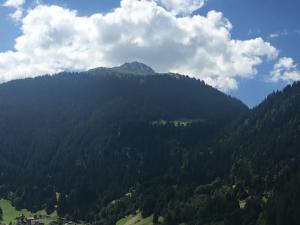 vista su una montagna con alberi e nuvole di Haus Ganeu a Gaschurn