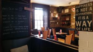 un comedor con mesas y sillas y una pizarra en The Orchard Hotel, en Falkirk