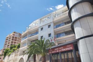 un edificio blanco con una palmera delante en Odalys City Beausoleil les Hauts de la Principauté, en Beausoleil