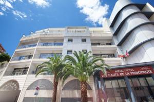 un edificio blanco con palmeras delante en Odalys City Beausoleil les Hauts de la Principauté, en Beausoleil