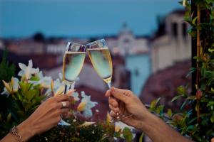 2 personnes tenant des verres de champagne dans l'établissement Hotel Firenze, à Venise