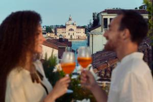 un groupe de personnes tenant des verres de vin dans l'établissement Hotel Firenze, à Venise